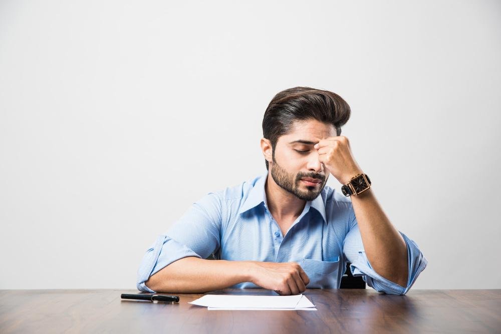 A stress looking Indian man.